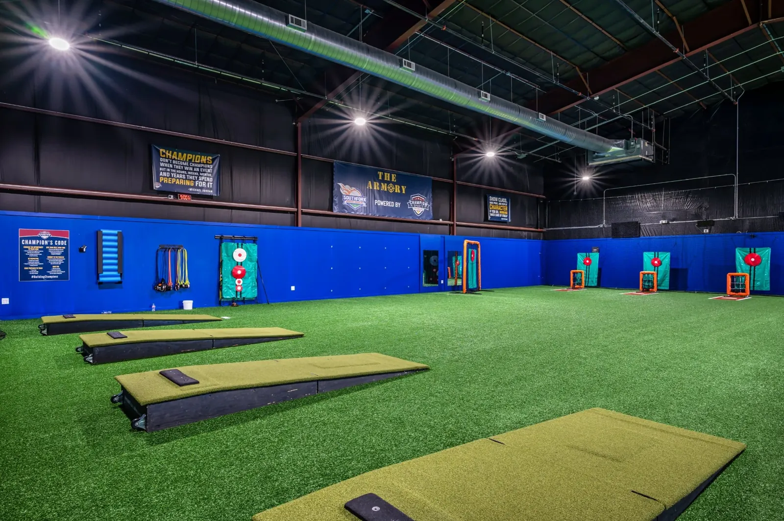 Throwing mats and target nets on turf under the Armory banner